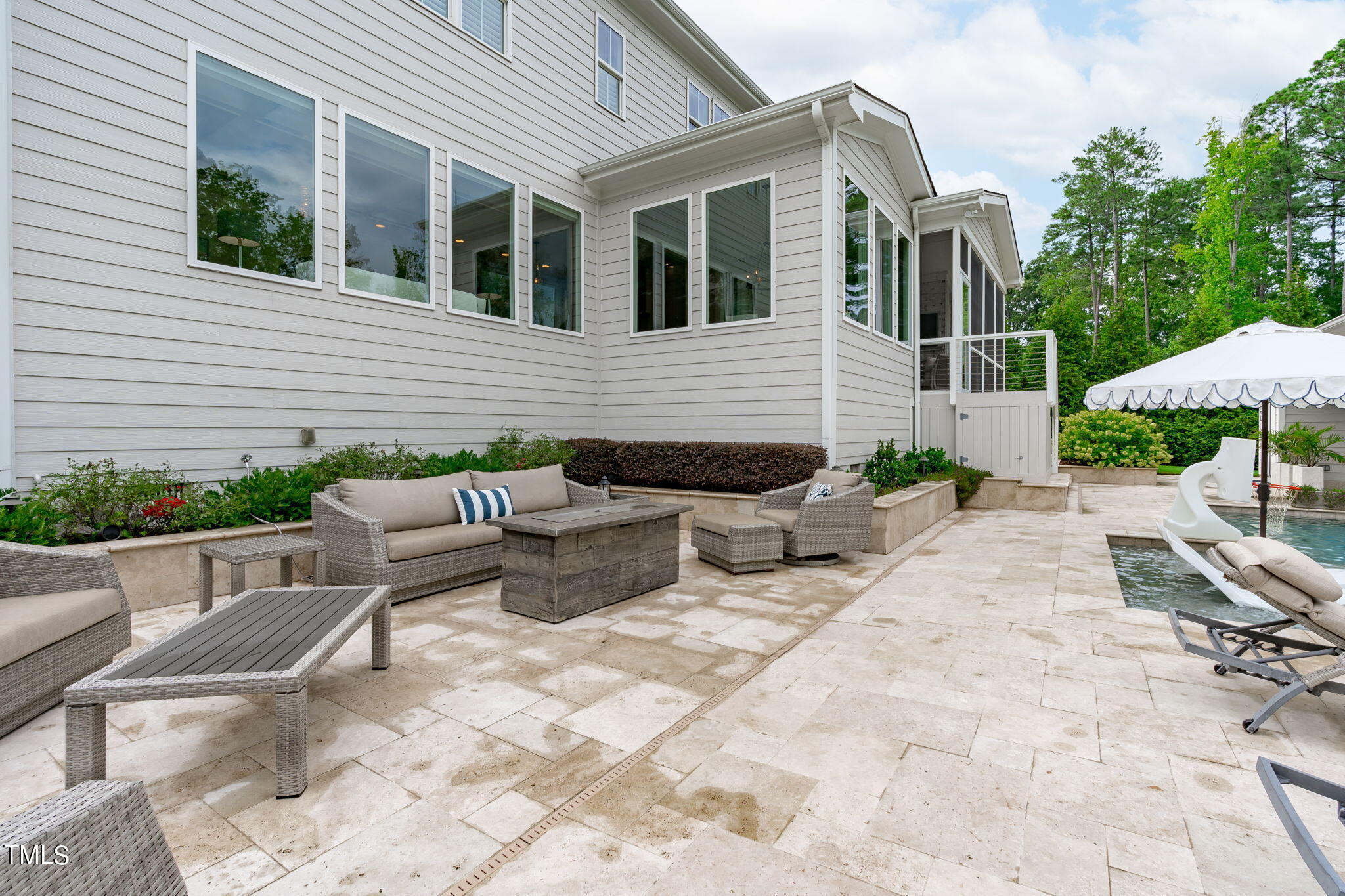3130 Mantle Ridge Drive Apex, NC 27502 - Photo 69 of 81 a view of a patio with couches table and chairs under an umbrella