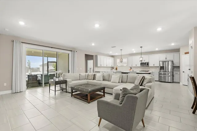 a kitchen with stainless steel appliances kitchen island granite countertop a sink a stove a refrigerator and island with wooden floor