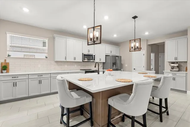 a kitchen with stainless steel appliances a sink stove and cabinets