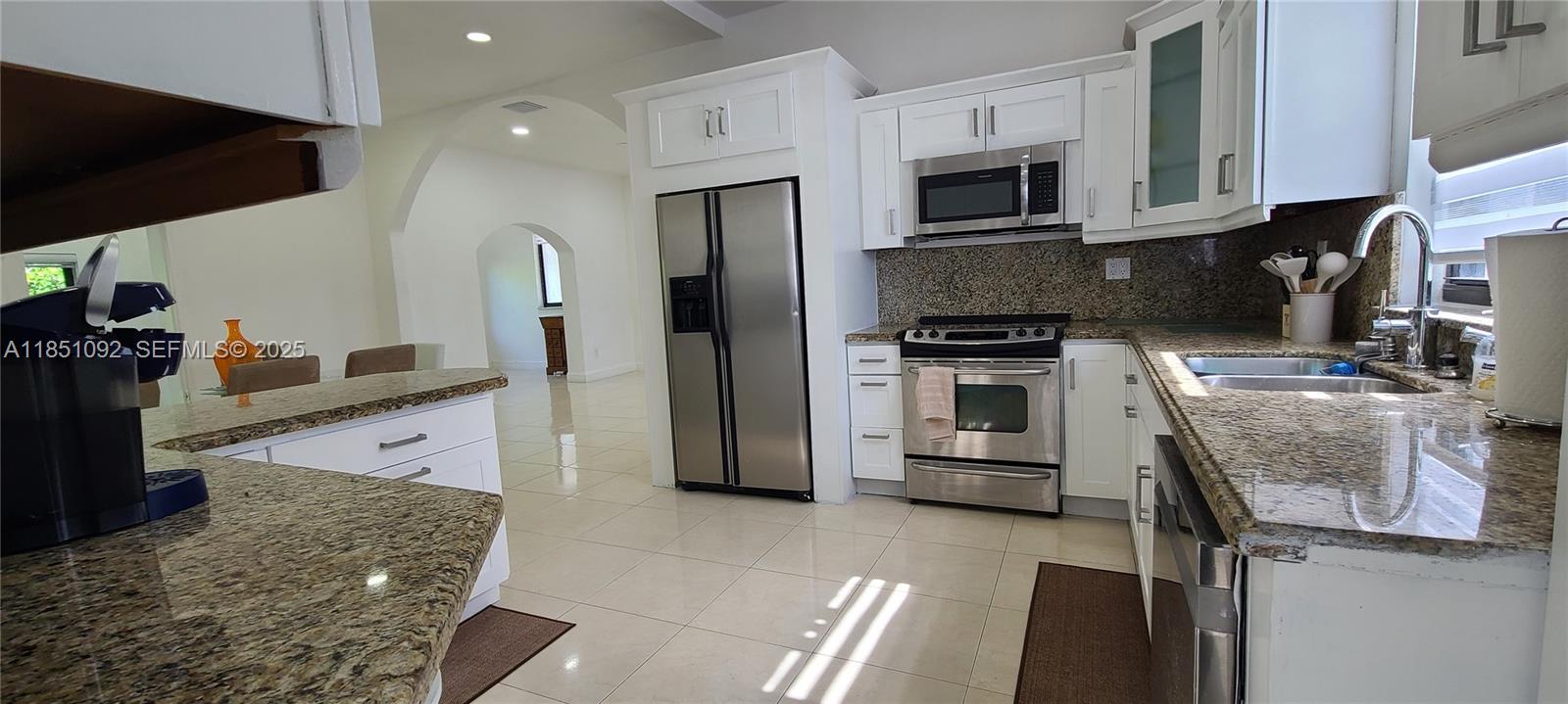 1721 Southwest 24th Terrace Miami, FL 33145 - Photo 24 of 80 a kitchen with stainless steel appliances granite countertop a stove a sink and a microwave