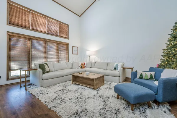a living room with furniture wooden floor and a large window