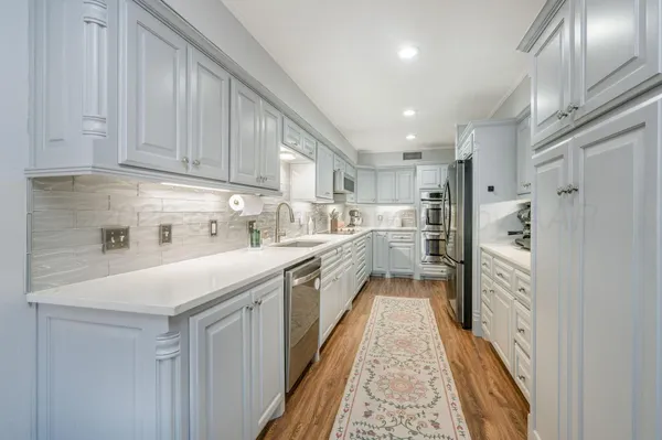 a kitchen with white cabinets and white appliances