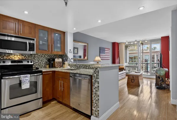 a kitchen with stainless steel appliances granite countertop a stove and cabinets