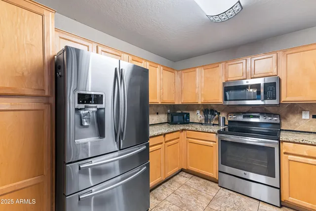 a kitchen with granite countertop stainless steel appliances stove microwave and sink