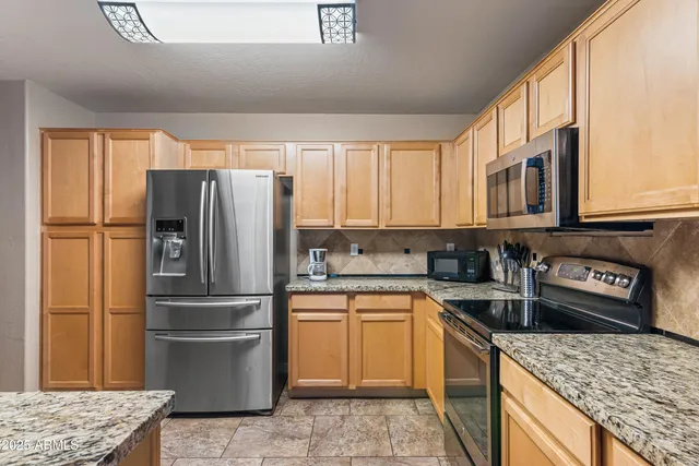 a kitchen with stainless steel appliances a refrigerator sink and microwave