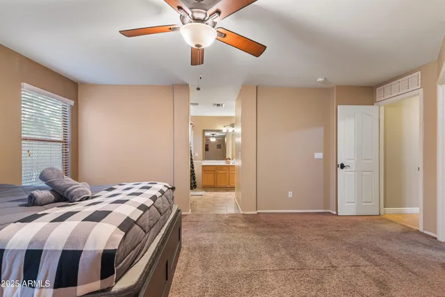 a bedroom with a large bed and a chandelier