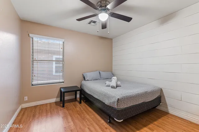 a white bed sitting in a bedroom next to a window