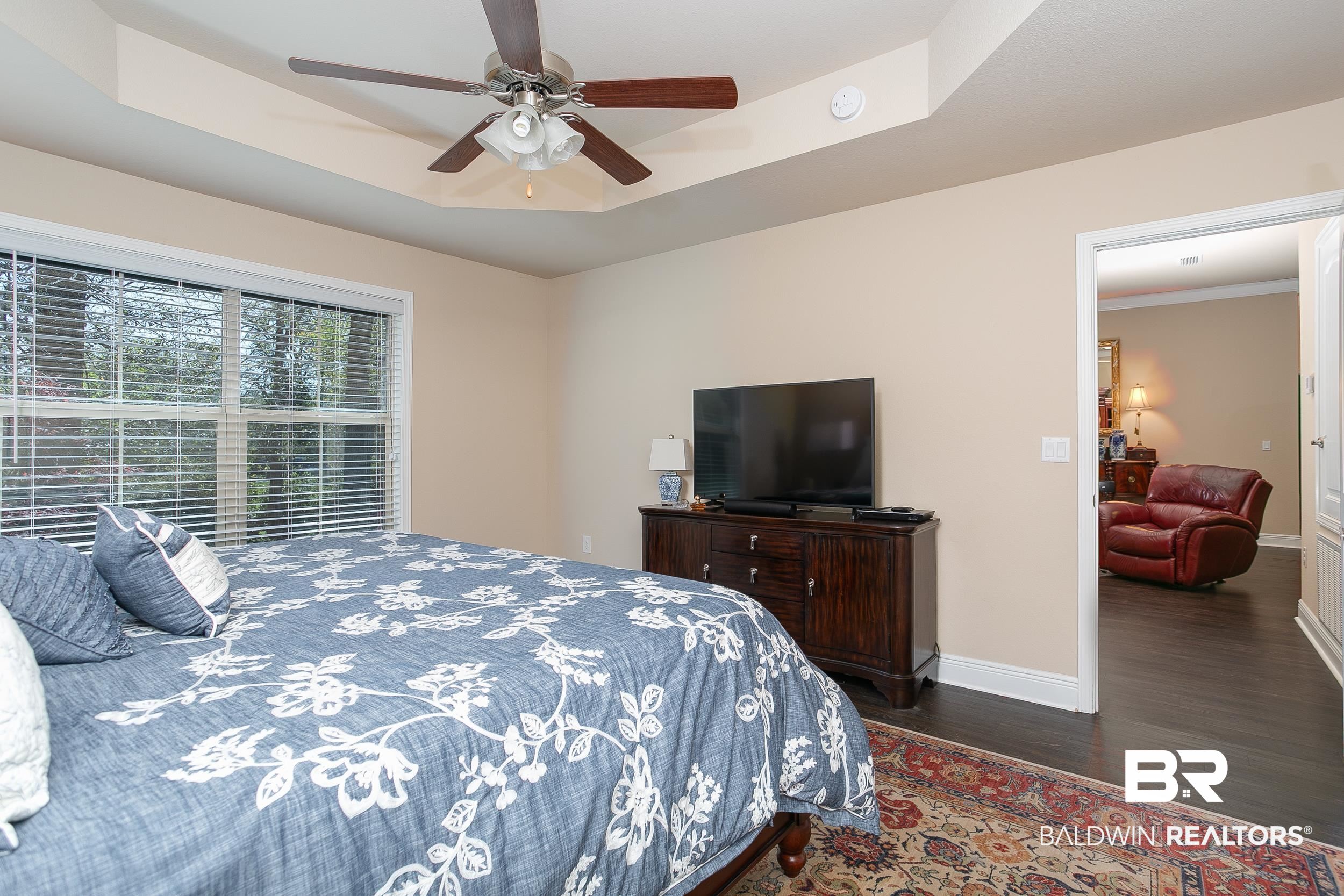 13154 Vincent Court Foley, AL 36535 - Photo 15 of 41 Bedroom featuring a ceiling fan, a tray ceiling, baseboards, and wood finished floors