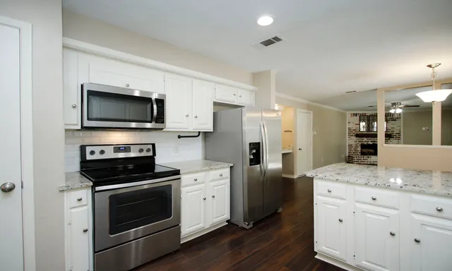 a kitchen with stainless steel appliances a stove microwave and refrigerator