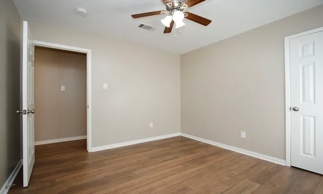 a view of an empty room with wooden floor