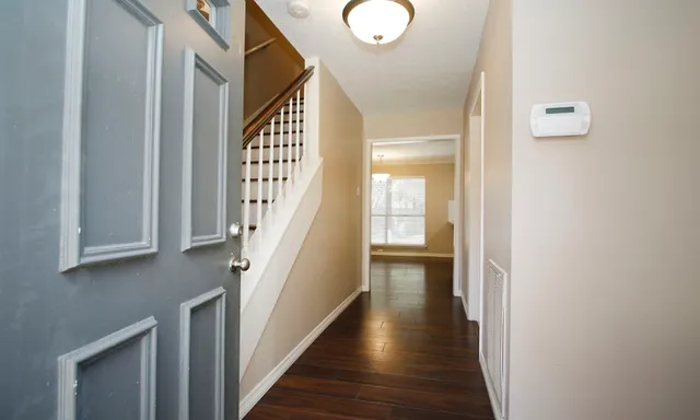 a view of a hallway with wooden floor and staircase