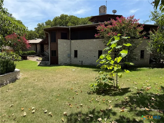 a view of a lush green forest with trees and some houses