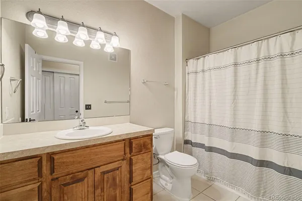 a bathroom with a sink a toilet a mirror and shower curtain