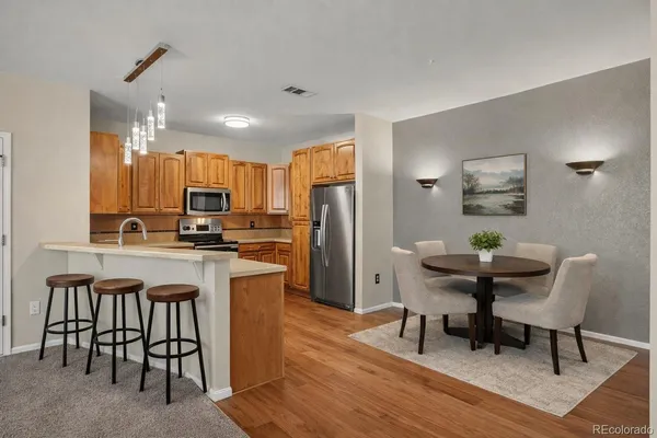 a kitchen with a table chairs refrigerator and microwave