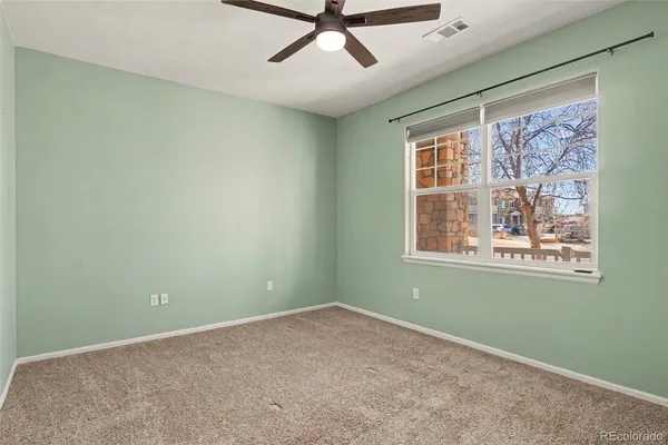 a view of a livingroom with a ceiling fan and window