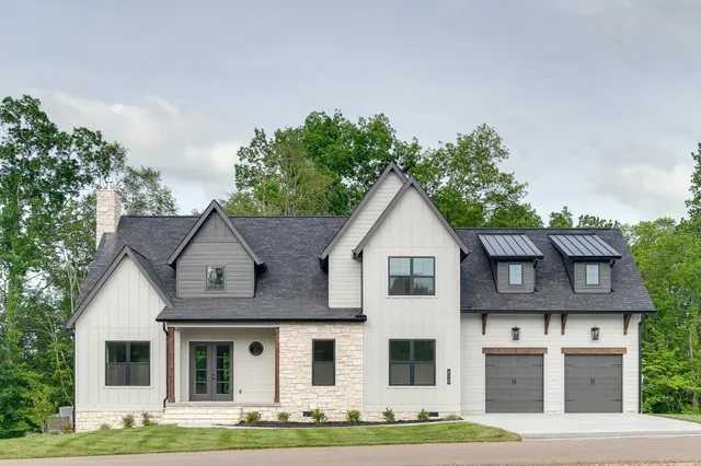 a view of a white house with large windows and a small yard