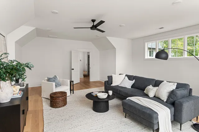 a living room with furniture and potted plants