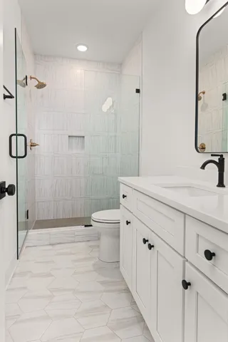 a bathroom with a sink a toilet and shower