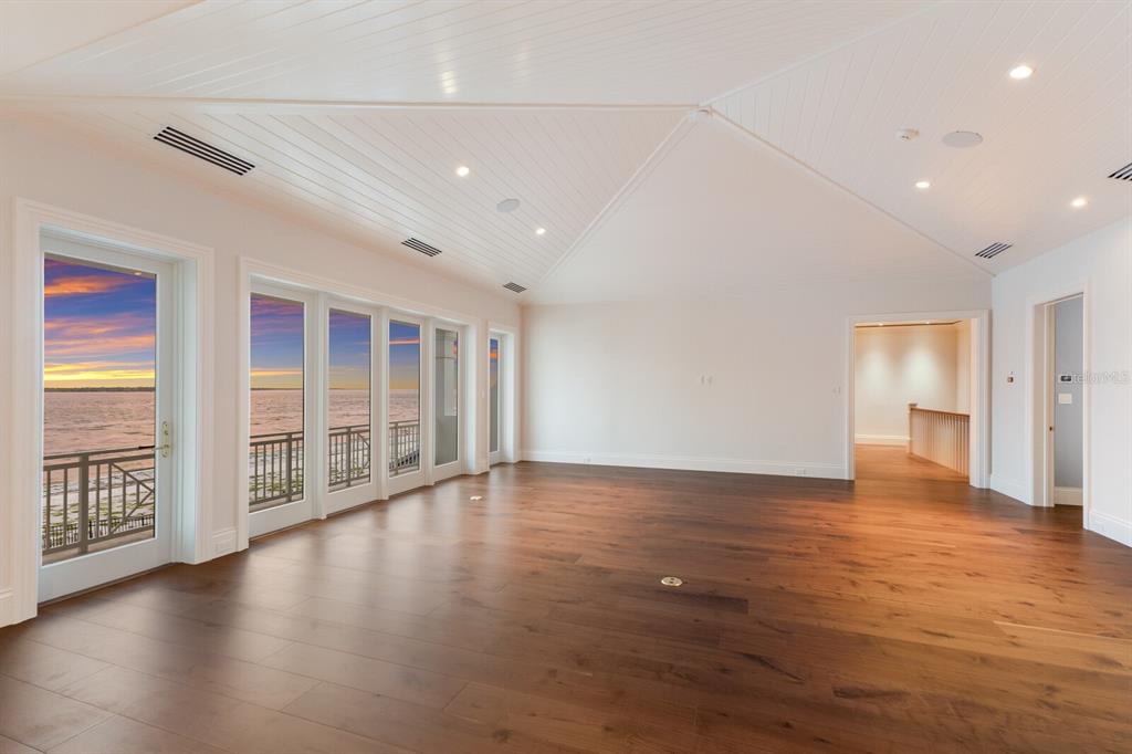 894 Hill Tide Lane Boca Grande, FL 33921 - Photo 24 of 100 an empty room with wooden floor and windows