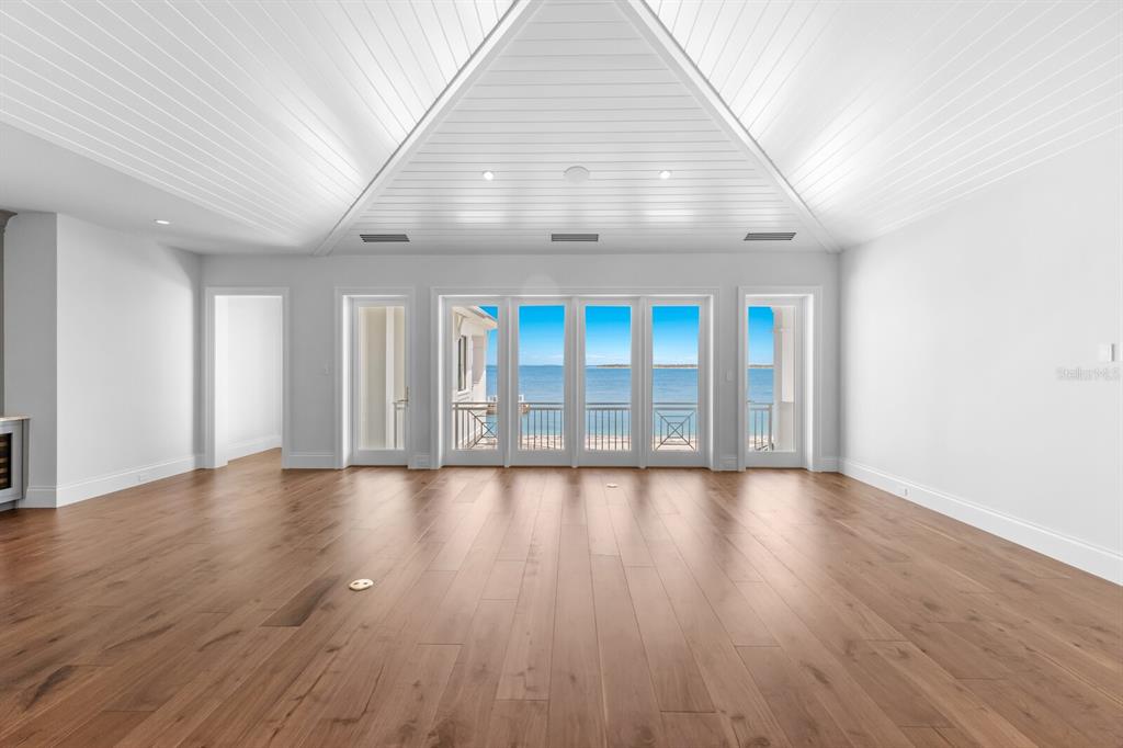 894 Hill Tide Lane Boca Grande, FL 33921 - Photo 75 of 100 an empty room with wooden floor and windows