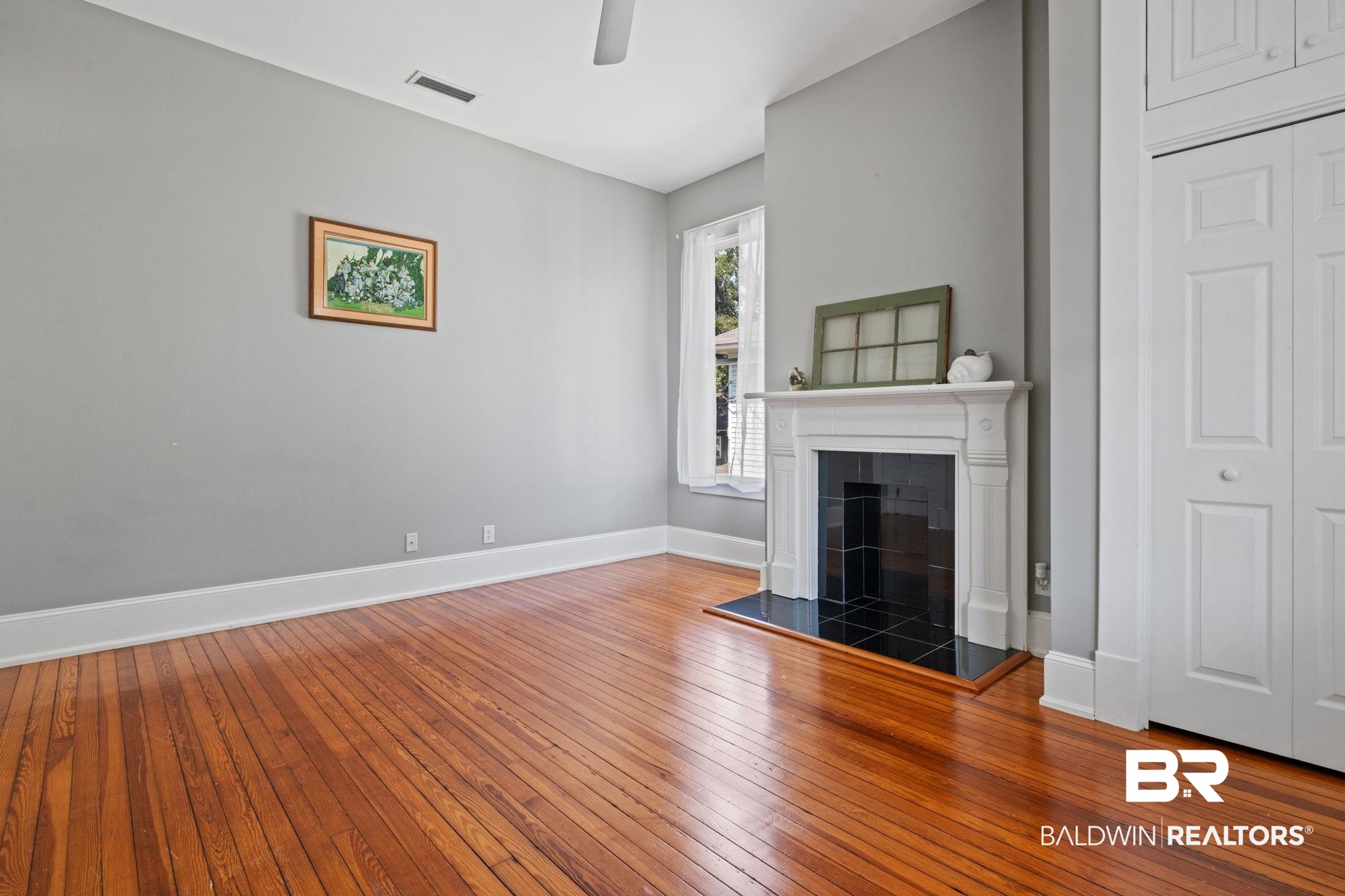 10 South Monterey Street Mobile, AL 36604 - Photo 30 of 45 Unfurnished living room featuring hardwood / wood-style flooring and a tiled fireplace