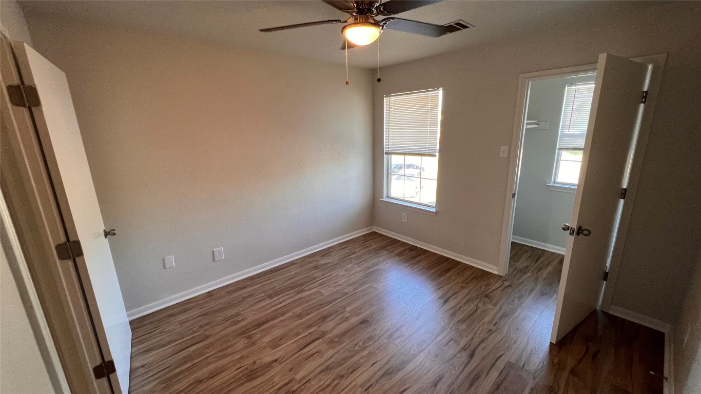 2865 Southampton Way, Unit B Round Rock, TX 78664 - Photo 7 of 9 a view of an empty room with wooden floor and a window