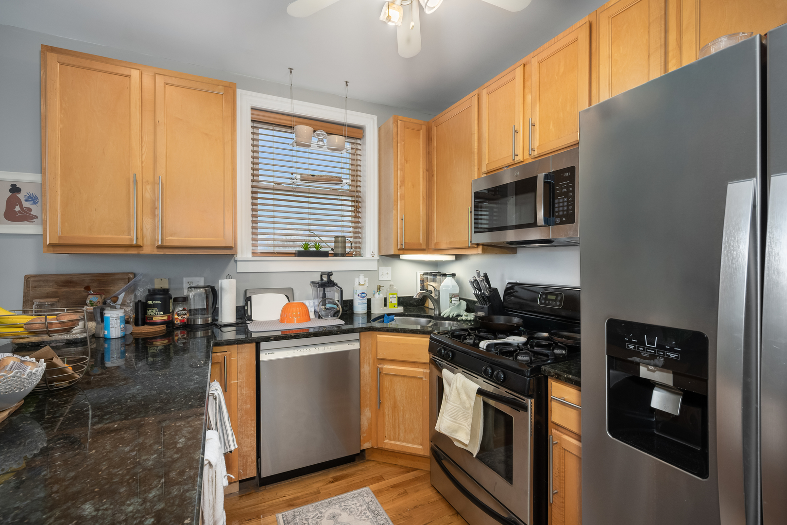 1710 North Whipple Street, Unit 3 Chicago, IL 60647 - Photo 9 of 17 a kitchen with stainless steel appliances granite countertop a stove a sink and a microwave
