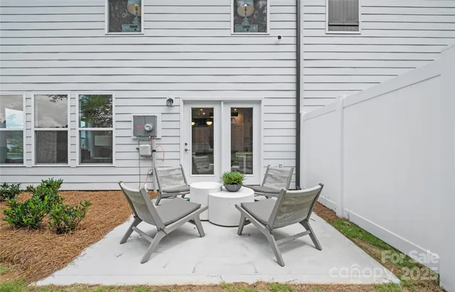 a view of a patio with couple of chairs and potted plants