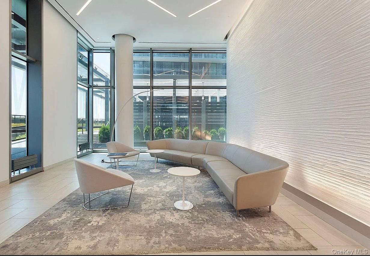 131-03 40 Road, Unit 10H Queens, NY 11354 - Photo 6 of 10 Lobby with expansive windows and a towering ceiling