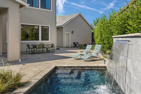 a view of a house with backyard and sitting area
