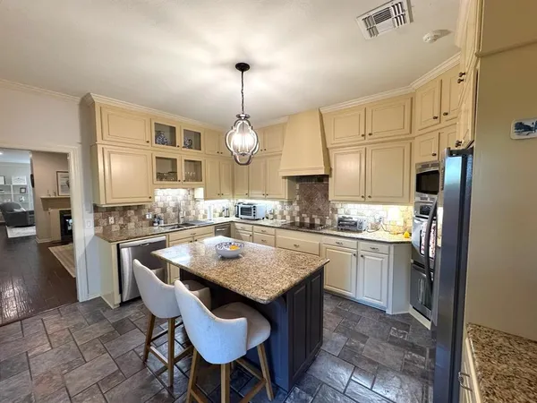 a kitchen with kitchen island granite countertop a sink a center island and cabinets