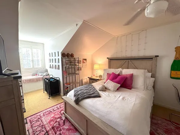 a living room with furniture a flat screen tv and a window