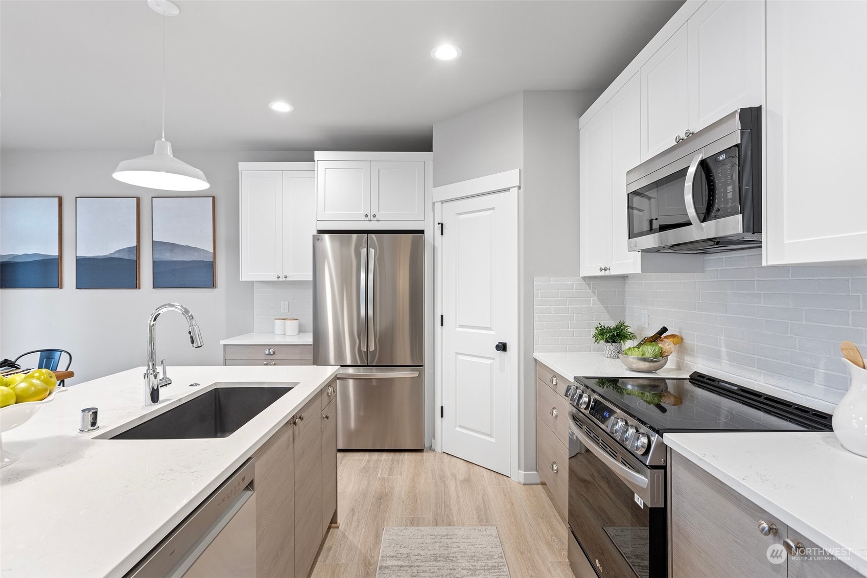 116 161st Street Southeast, Unit 1 Bothell, WA 98012 - Photo 11 of 37 a kitchen with stainless steel appliances a sink a stove a microwave a refrigerator a cabinets and wooden floor