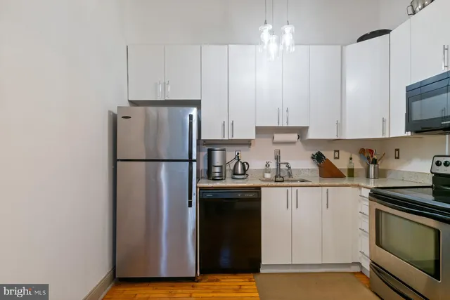 a kitchen with stainless steel appliances granite countertop a refrigerator stove a sink and a granite counter tops