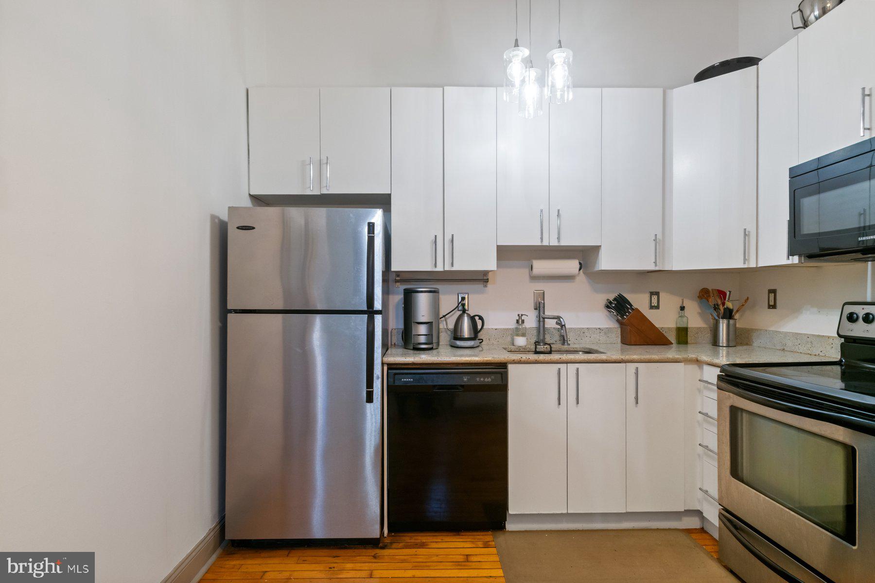 511 South Bond Street, Unit 206 Baltimore, MD 21231 - Photo 12 of 27 a kitchen with stainless steel appliances granite countertop a refrigerator stove a sink and a granite counter tops