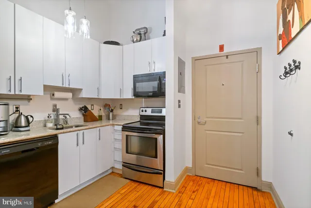 a kitchen with stainless steel appliances a stove refrigerator and cabinets