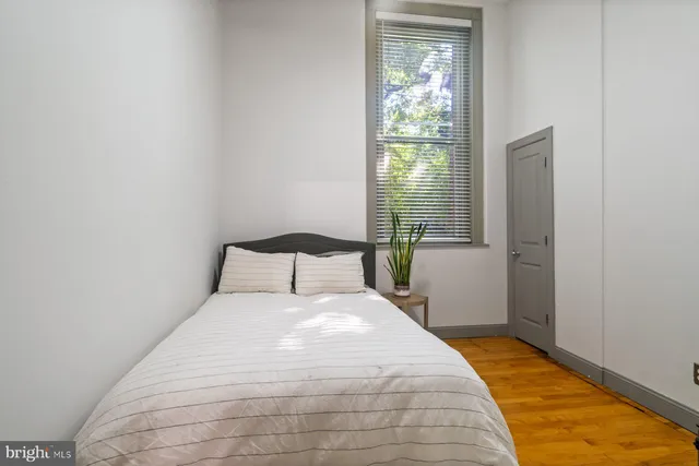 a large bed sitting in a bedroom next to a window
