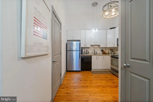 a kitchen with stainless steel appliances granite countertop a refrigerator and a stove top oven