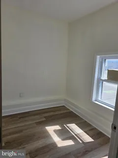 a view of a small space with wooden floor and a window