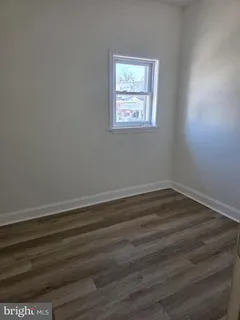 a view of a room that has wooden floor and white walls