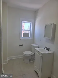 a bathroom with a toilet sink and mirror