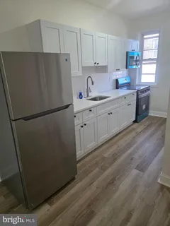 a kitchen with stainless steel appliances a refrigerator sink and cabinets
