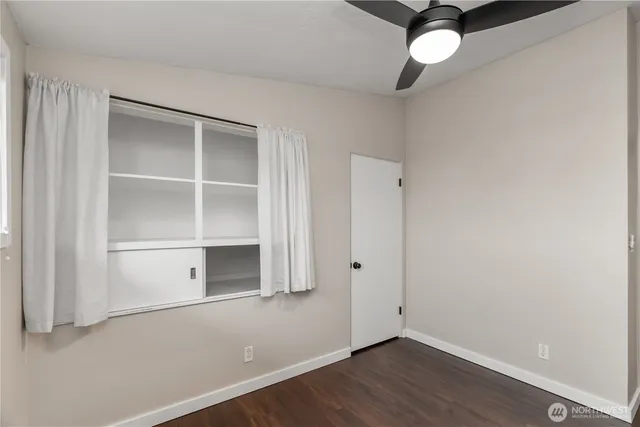 an empty room with a window and a ceiling fan