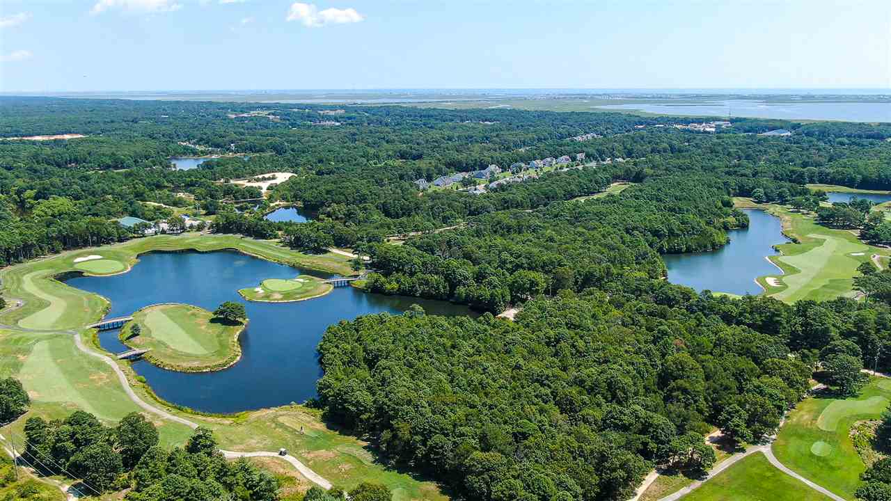 an aerial view of a house with a garden and lake view