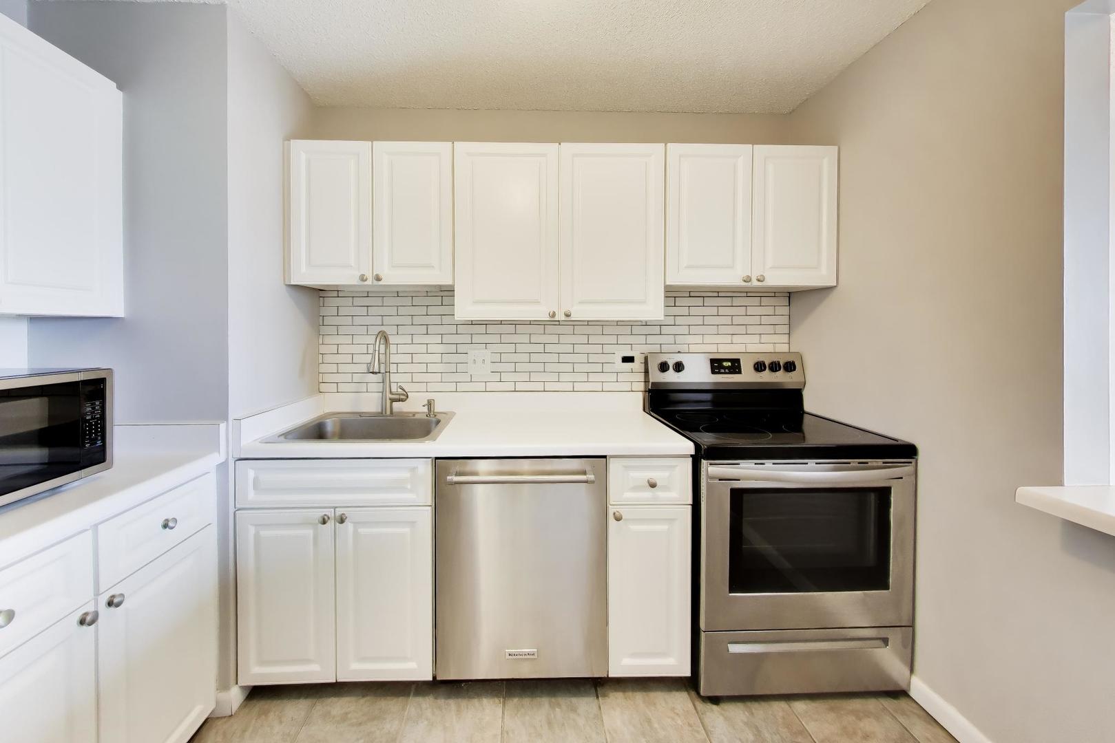 111 West Maple Street, Unit 1503 Chicago, IL 60610 - Photo 15 of 39 a kitchen with a stove sink and cabinets