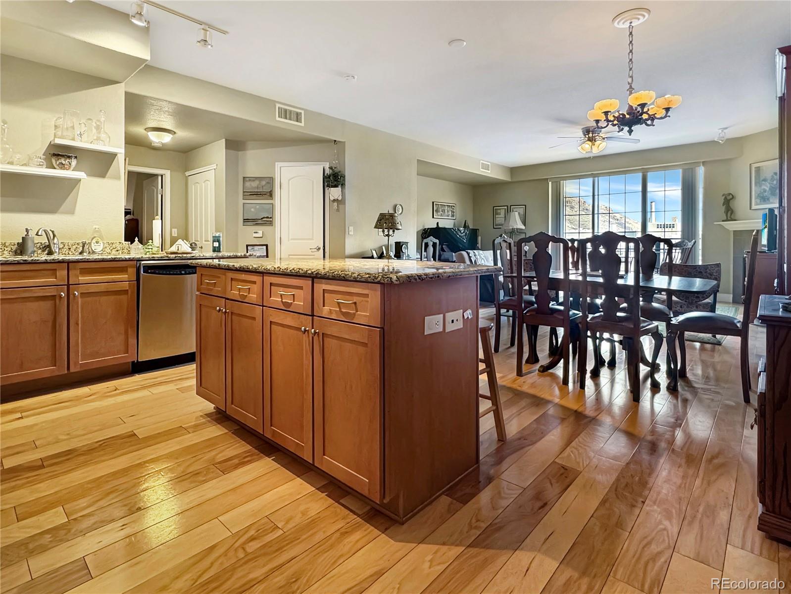 620 11th Street, Unit 306 Golden, CO 80401 - Photo 3 of 22 a kitchen with stainless steel appliances granite countertop a dining table chairs and granite counter tops