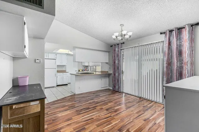 a open kitchen with kitchen island a stove a sink dishwasher and white cabinets with wooden floor