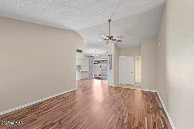 a view of empty room with wooden floor and window