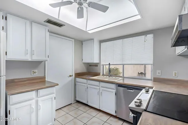 a kitchen with a sink window and cabinets