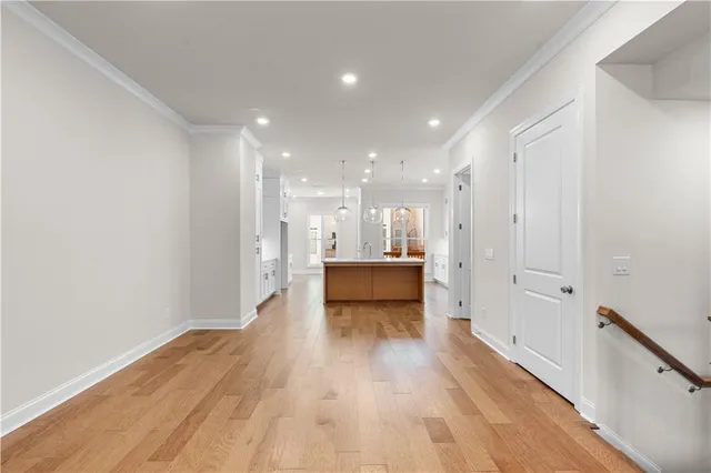 a large kitchen with granite countertop a sink white cabinets and stainless steel appliances